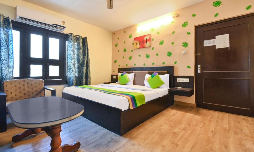 a hotel room with a bed and a desk and a table at Treebo Trend Siddharth in Ajmer