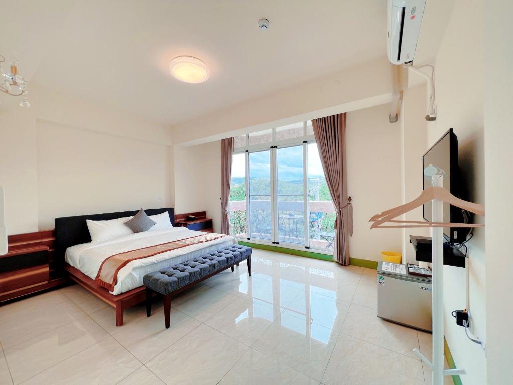 a bedroom with a bed and a large window at Mu Travel B&B in Kenting