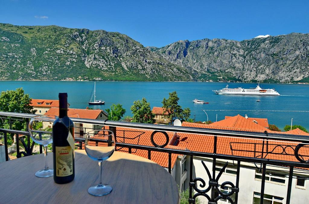 a bottle of wine and two glasses on a table at Apartments Scorpio in Kotor