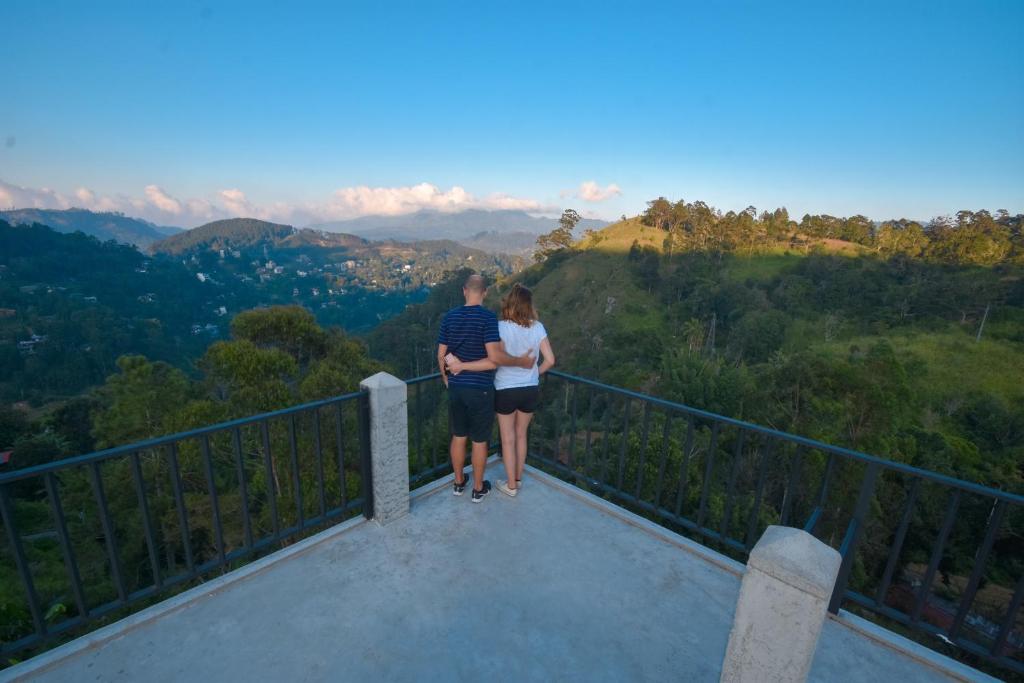 Un uomo e una donna in piedi sopra una torre di osservazione di Cozy Cottage Ella a Ella