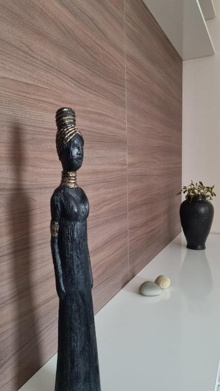 Eine Statue einer Frau, die auf einem Tisch sitzt. in der Unterkunft Râșnov Loft in Râșnov