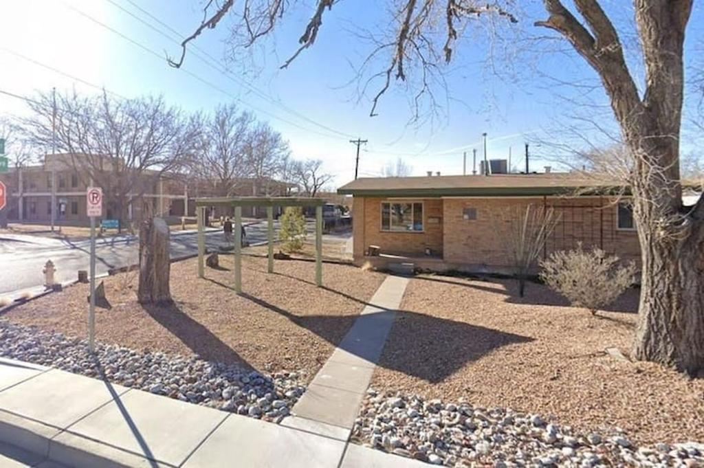 a building with a tree and a stop sign at Warm and Welcoming 2BR close to UNM North Campus in Albuquerque