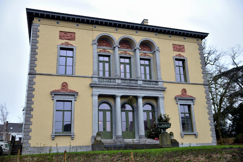 un gran edificio amarillo con ventanas en la parte superior en Villa Servais en Halle