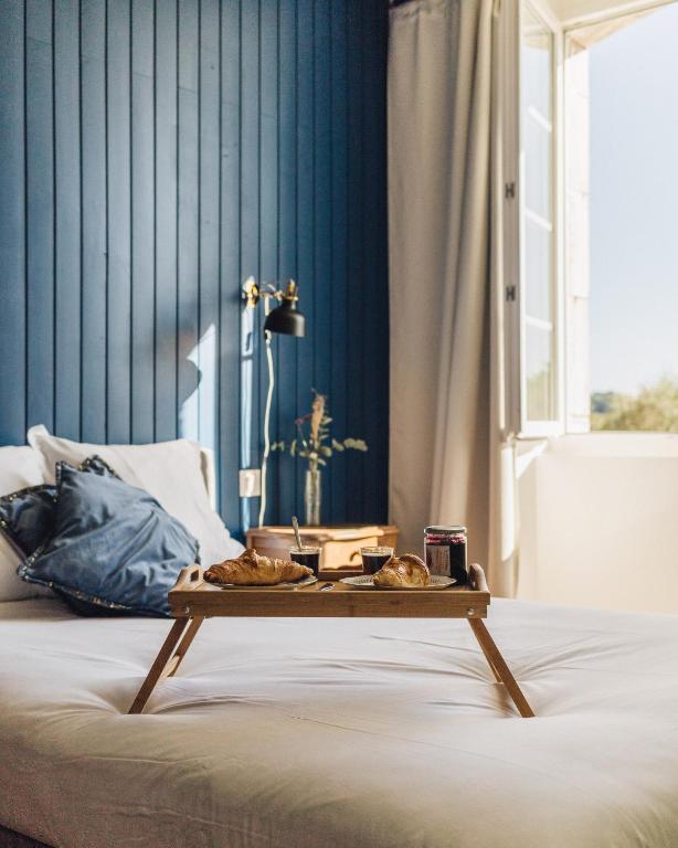 un lit avec un plateau de nourriture dessus dans l'établissement Le Bel Endroit - Joli Studio vue jardin, à Bidache