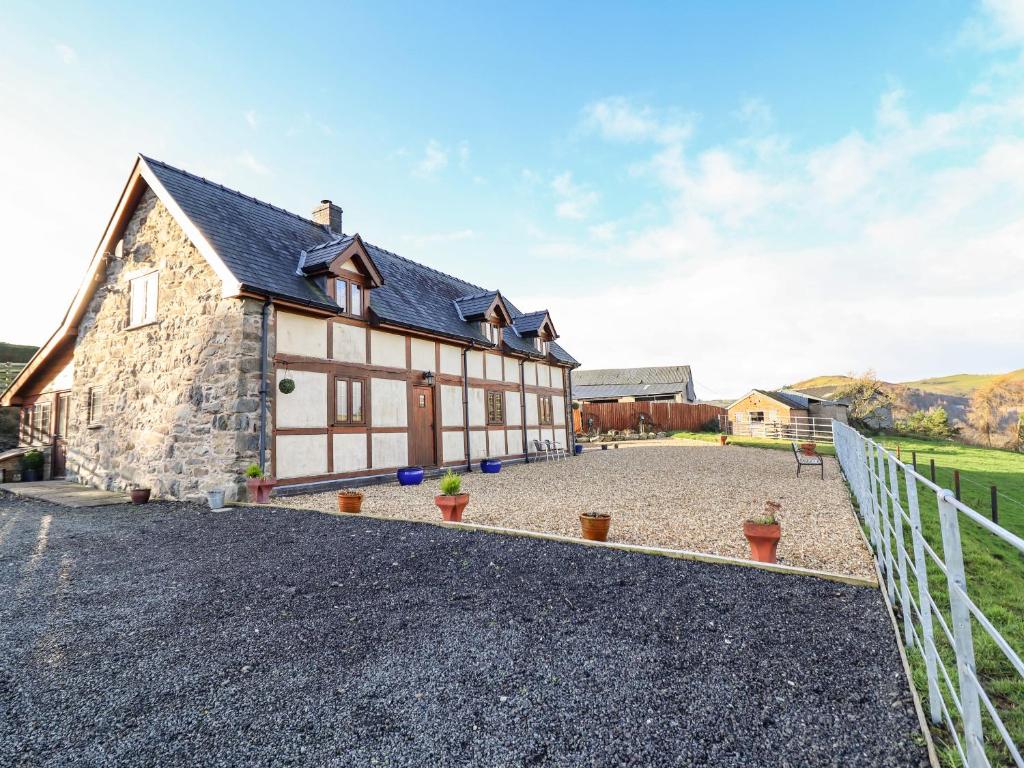 an exterior view of a barn with a gravel driveway at The Old House in Llanidloes