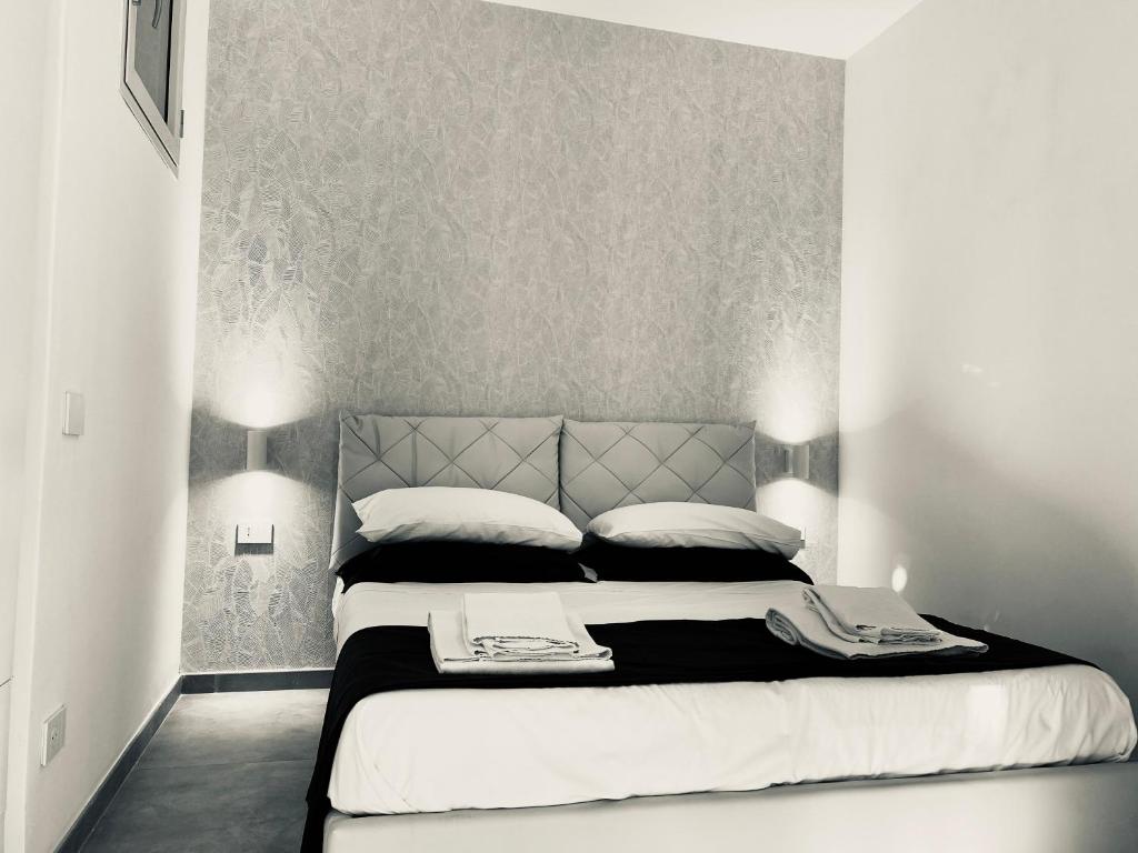 una camera da letto in bianco e nero con un grande letto di Palinuro blue holiday home a Palinuro