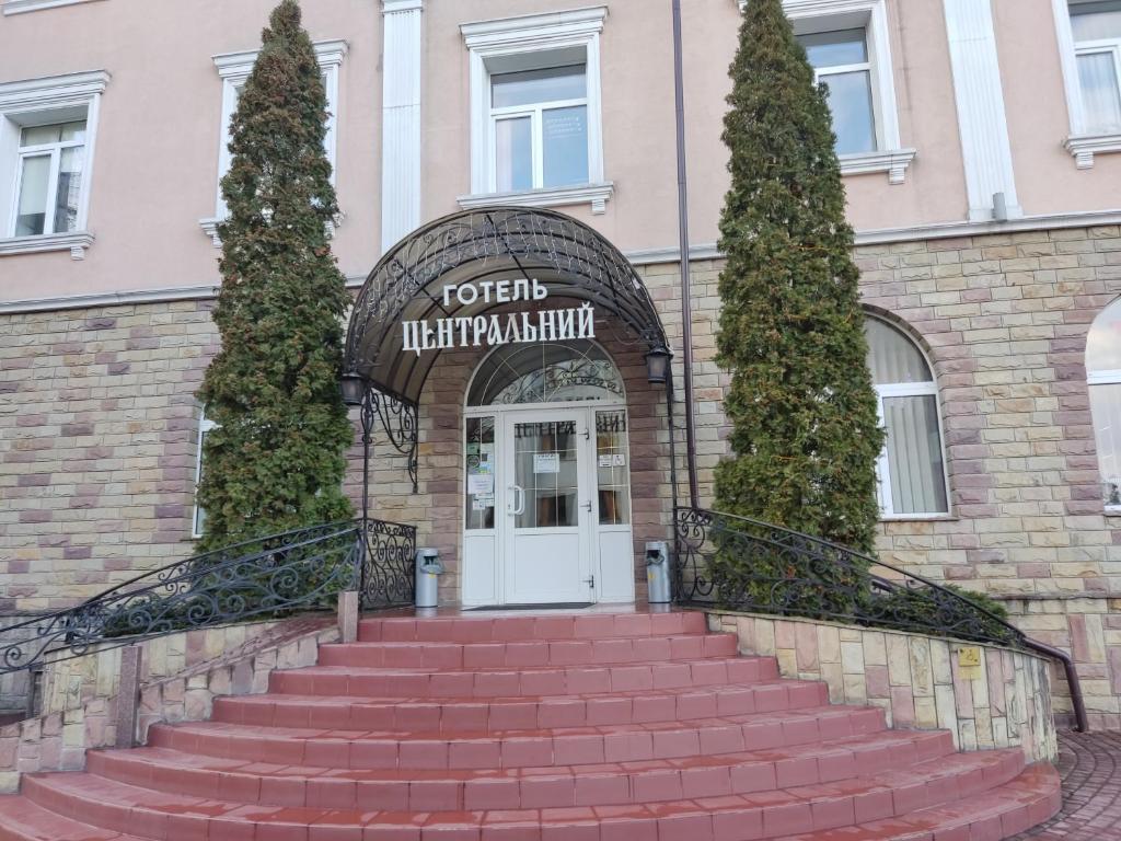 un conjunto de escaleras que conducen a la puerta principal de un edificio en Tsentralniy Hotel en Khmelʼnytsʼkyy