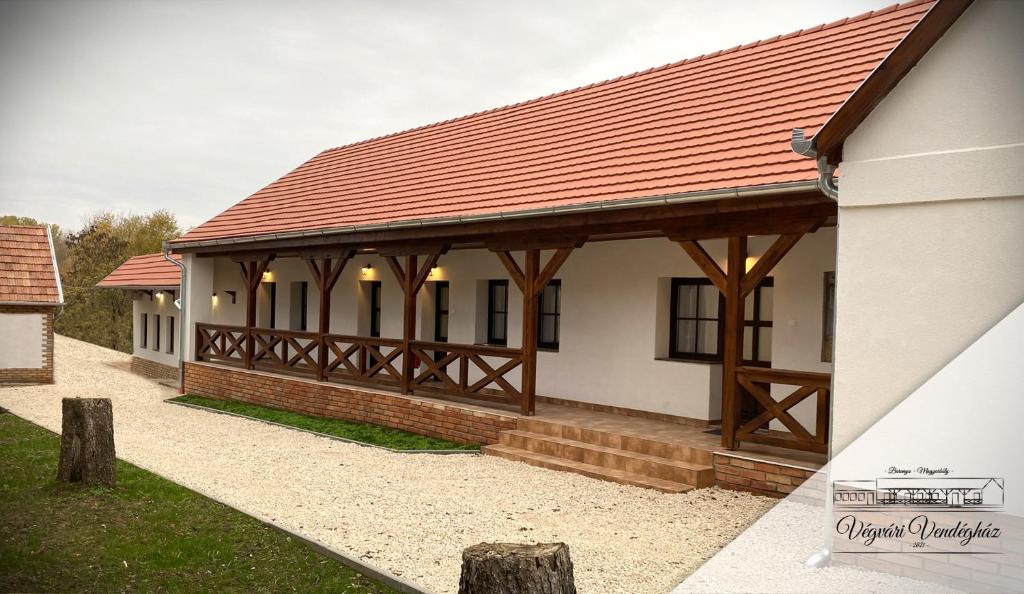 a house with a red roof and a pavilion at Végvári Vendégház in Magyarbóly