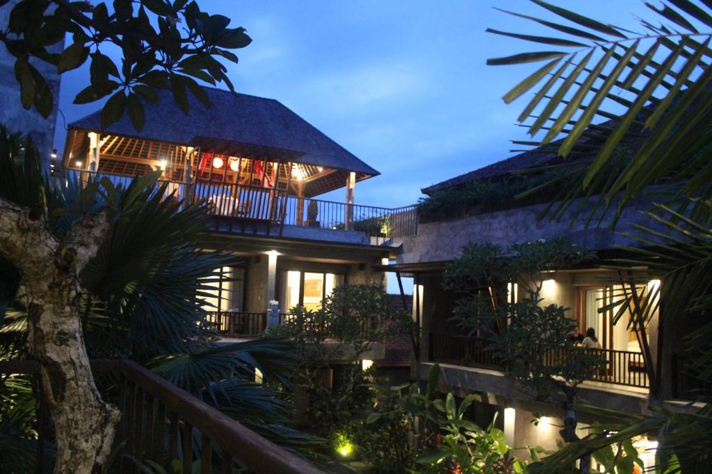 a resort building with a balcony at night at Purana Suite Ubud in Ubud