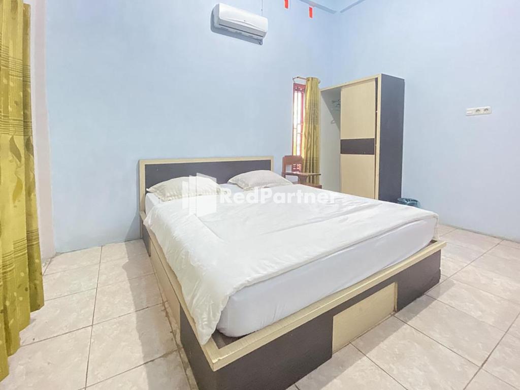 ein Schlafzimmer mit einem großen Bett in einem Zimmer in der Unterkunft Homestay Tirtasari Pinrang City Center Mitra RedDoorz in Pinrang