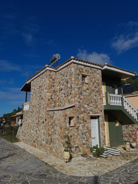 a stone building with a balcony on top of it at Edem Studios in Syvota