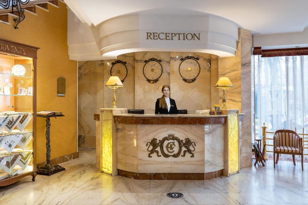 a woman standing at a reception desk in a lobby at Eurohotel in Lviv