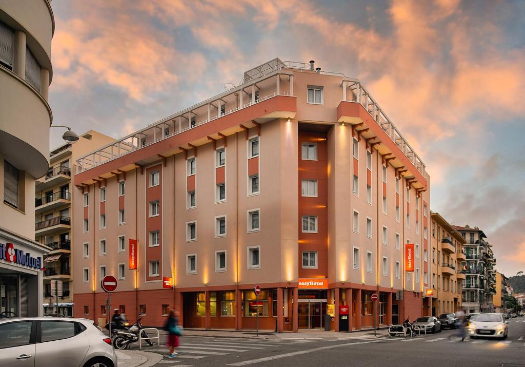 un grand bâtiment dans une rue de la ville avec des voitures dans l'établissement easyHotel Nice Palais des Congrès – Old Town, à Nice