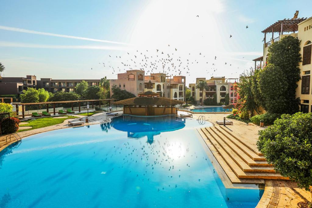 una gran piscina con aves volando en el cielo en Tala Bay Residence, en Áqaba