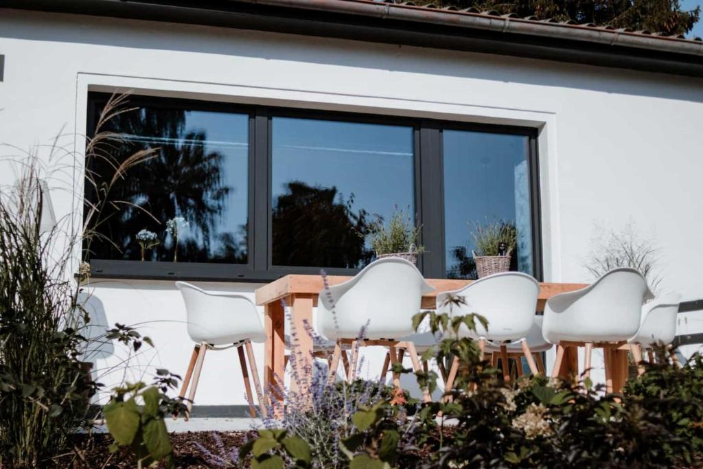 een groep witte stoelen en een tafel voor een raam bij Ferienhaus Pier 1 in Ahlbeck