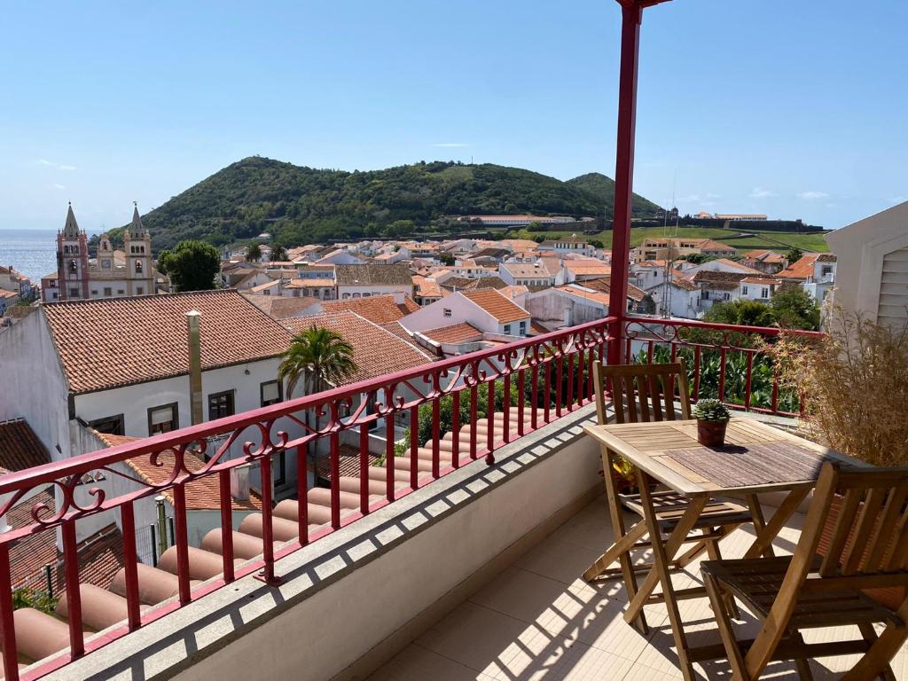 balcón con mesa y vistas a la ciudad en Telhados d'Angra AL, en Angra do Heroísmo