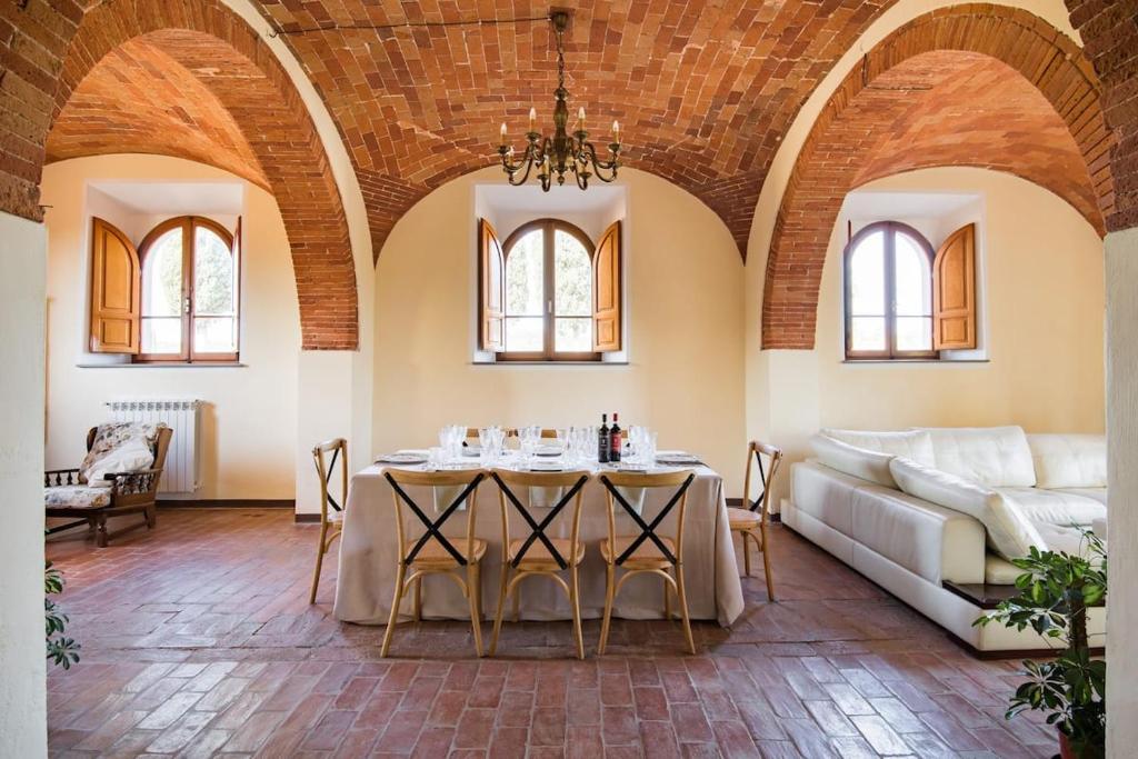 sala de estar con mesa y sofá en Villa Eleonora, en Lucignano