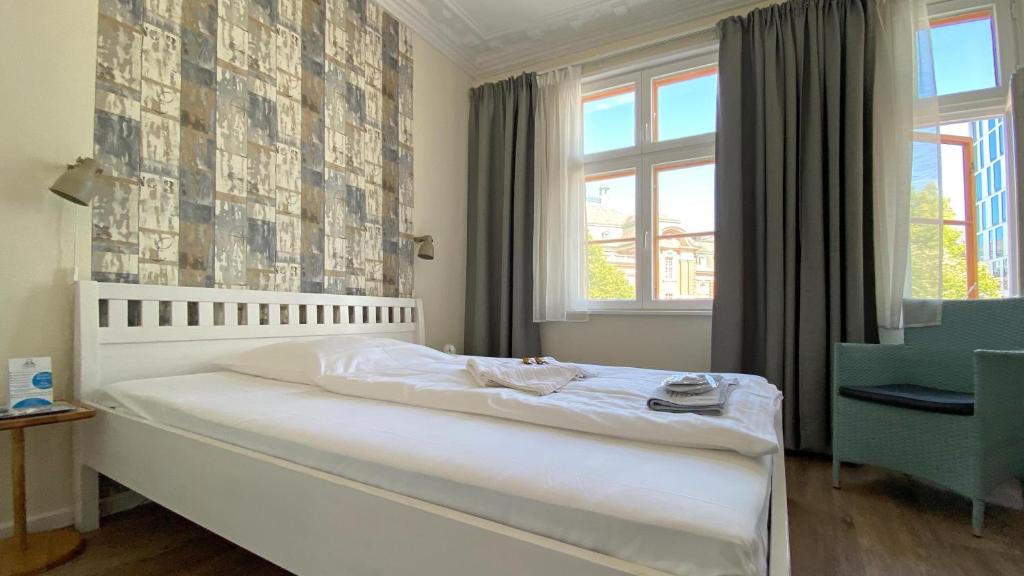 a bedroom with a white bed and a window at Frauenhotel Hanseatin - Women Only in Hamburg