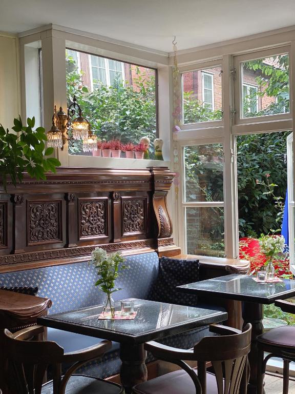 a restaurant with two tables and two windows at Frauenhotel Hanseatin - Women Only in Hamburg