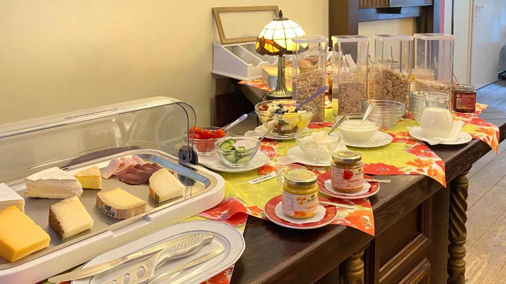 a table with cheese and other foods on it at Frauenhotel Hanseatin - Women Only in Hamburg