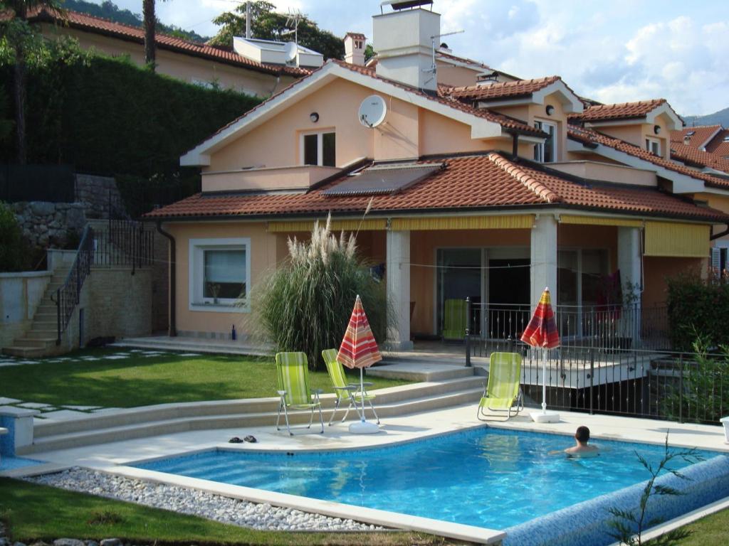 Villa con piscina frente a una casa en Apartments Bruk, en Lovran