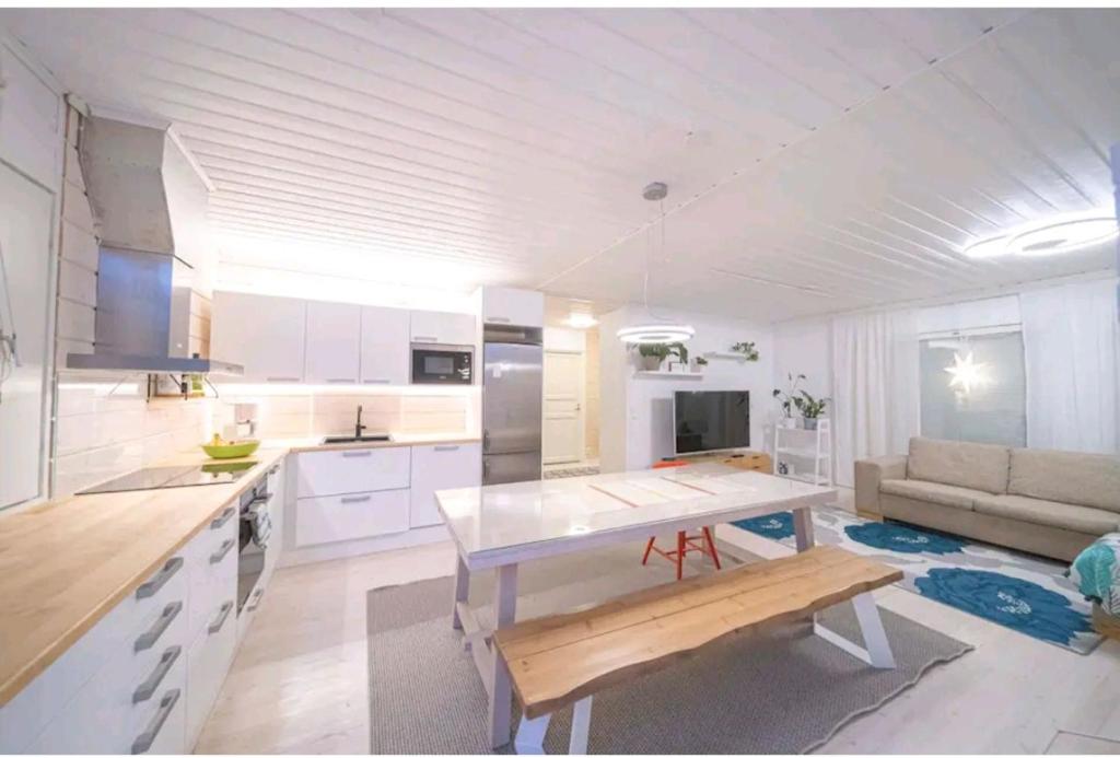 Una cocina y una sala de estar con una mesa y un sofá. en Villa ArcticFox Rovaniemi, en Rovaniemi