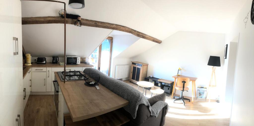 cocina y sala de estar con mesa y sillas en Appartement Cosy avec Balcon au calme proche Gare, en Bernay