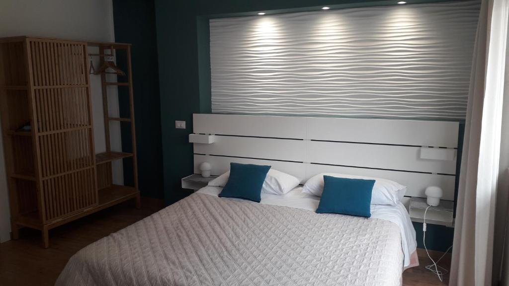 テッラジーニにあるI Faraglioni Comfort Roomsのベッドルーム(白いベッド、青い枕付)