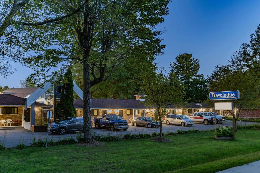 a hotel with cars parked in a parking lot at Travelodge by Wyndham Bracebridge in Bracebridge