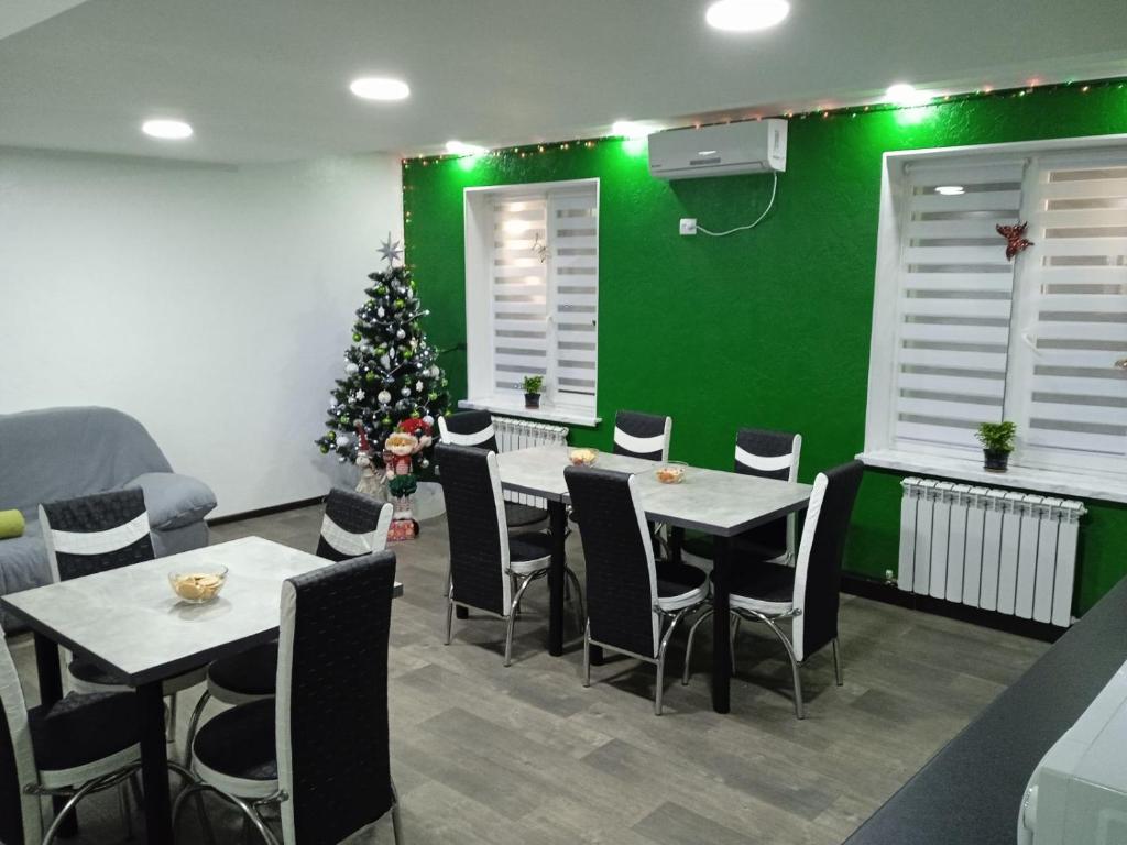 a dining room with two tables and a christmas tree at Green cost in Boryspilʼ