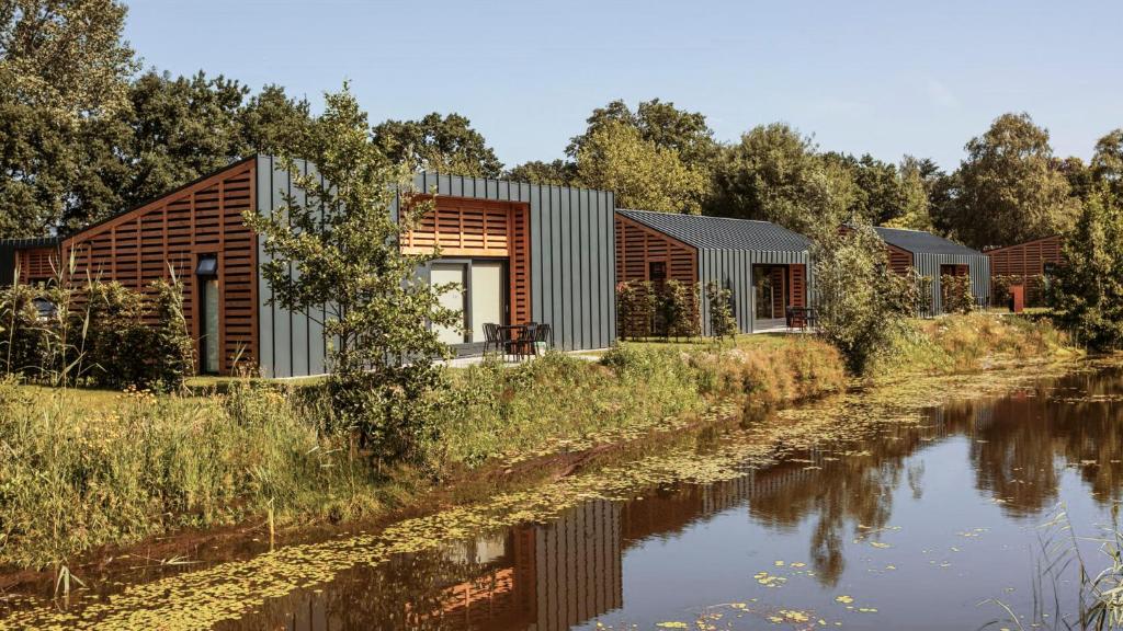una casa a orillas del río con vistas a ella en Suitelodges Gooilanden en Loosdrecht