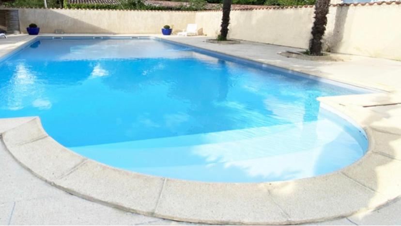 a large swimming pool with blue water at Hotel - Restaurant de la Paix in Barbotan-les-Thermes