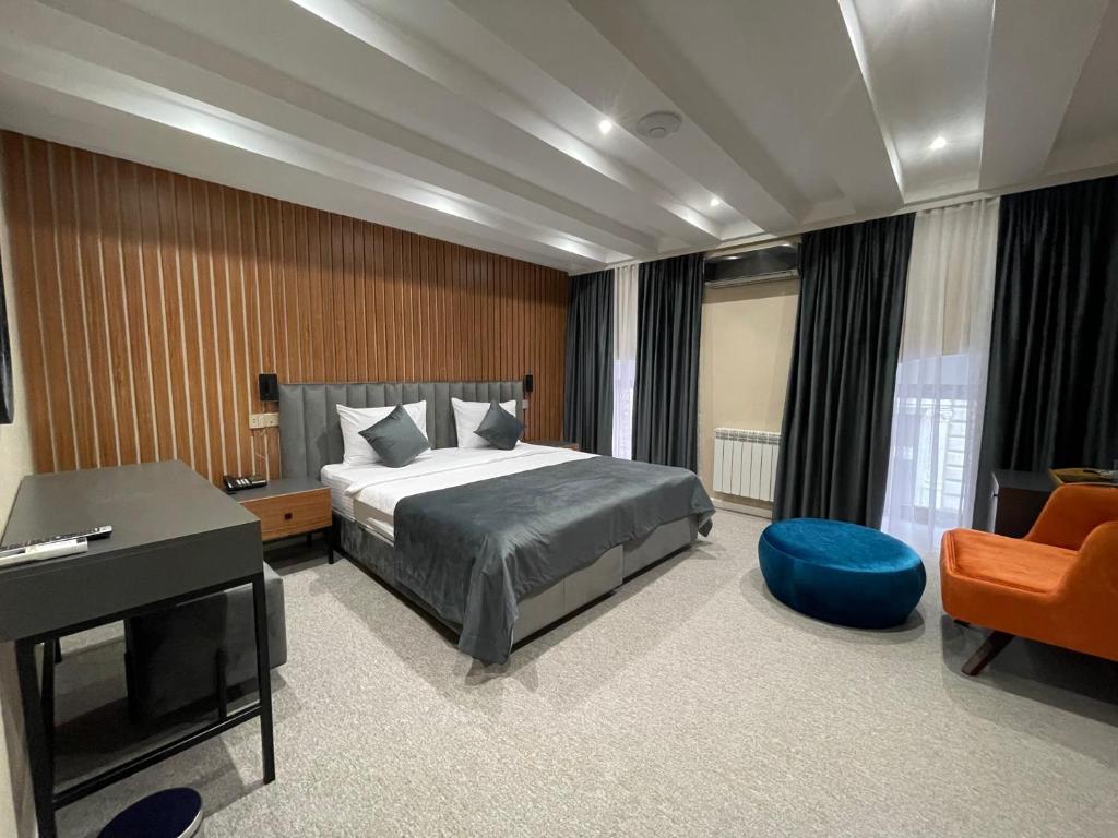 a bedroom with a bed and a desk and a chair at Eleven Hotel Baku in Baku