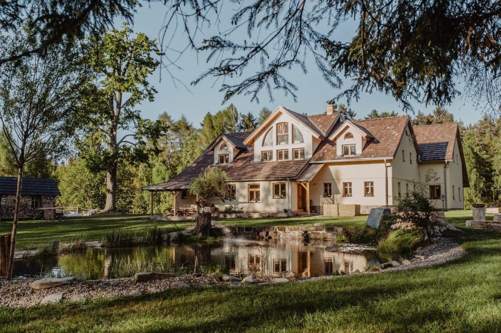 a house with a pond in front of it at Krasná Samota in Chřibská