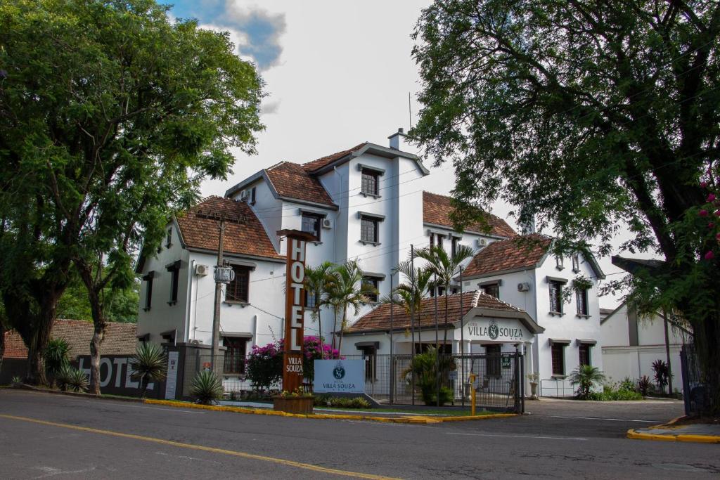 a large white building on the side of a street at Hotel Villa Souza Ltda in Santa Cruz do Sul