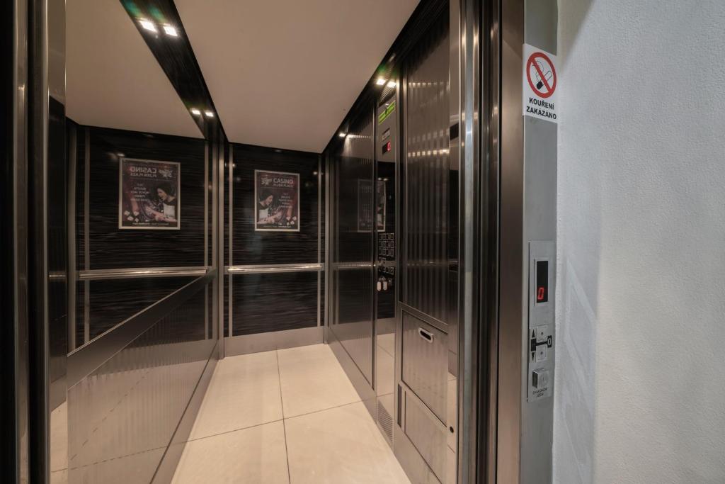 a walk in shower in a bathroom with black walls at Hotel Astory Plzeň in Plzeň