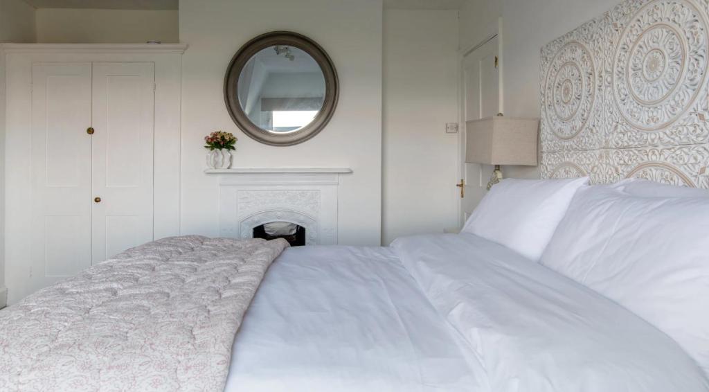 a white bed in a white bedroom with a mirror at Tranquil Beachfront Beautiful 2-Bed Apartment in Deal