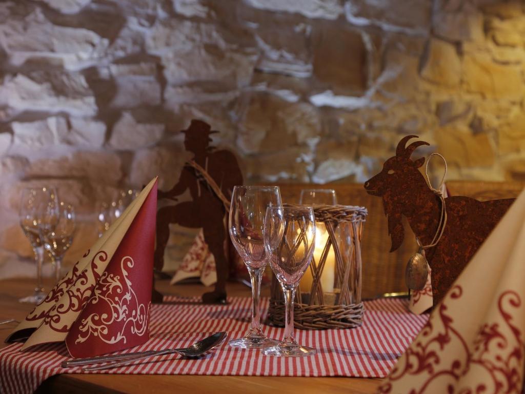 una mesa con copas de vino en un mantel rojo y blanco en Gaisbock der DorfUrlaub, en Fischen