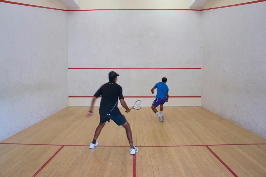two men playing a game of tennis in a gym at Constance Ephelia in Port Glaud