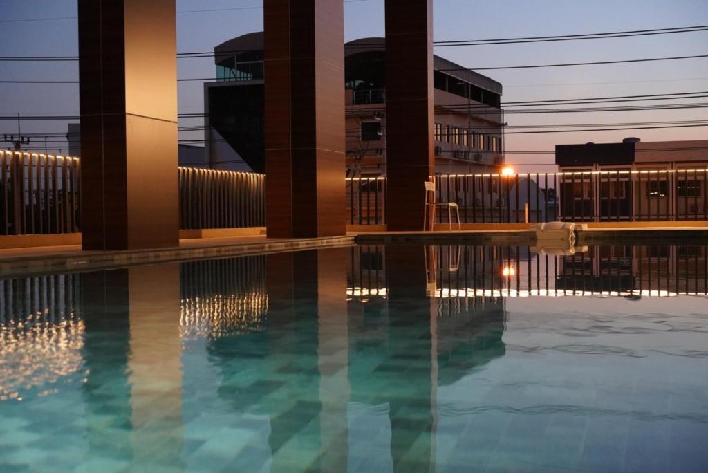 a swimming pool in front of a building at S3 Huahin Hotel in Hua Hin