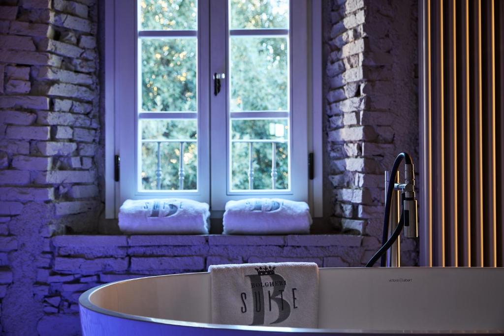 a bath tub sitting in front of a window at Bolgheri Wine Suite in Bolgheri