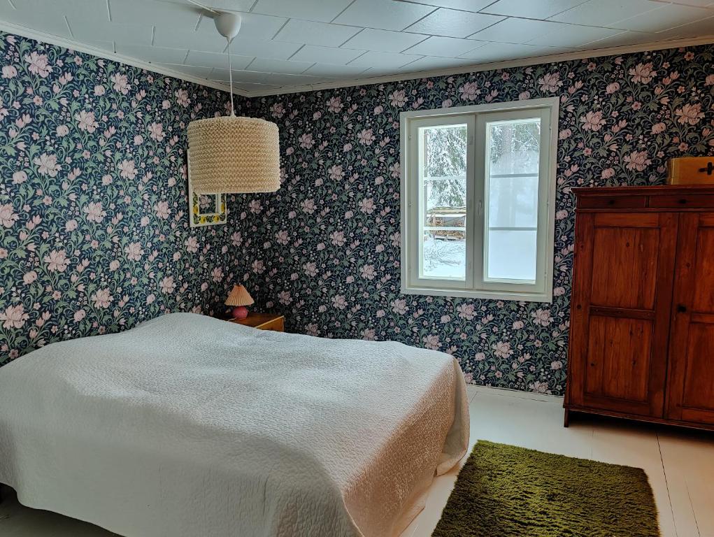 un dormitorio con una cama y una ventana en Hiljanrinne, en Mommila Hietoinen