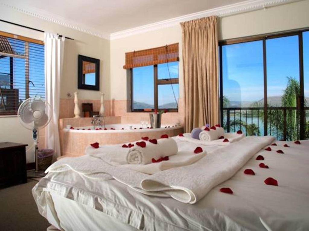 a bedroom with two beds with red roses on them at La Dolce Vita Guest House in Hartbeespoort