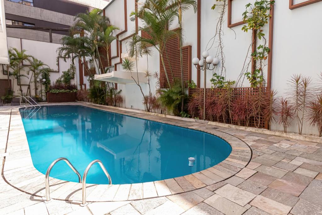 a swimming pool in front of a building at H4 La Residence Paulista in São Paulo