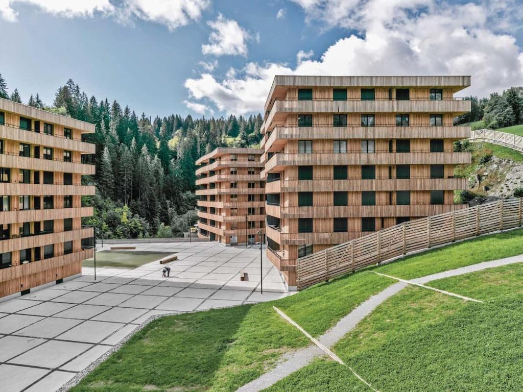 un gran patio con 2 edificios altos y césped en Ferienwohnung 3,5 Zimmer direkt an Ski- und Bikepiste en Flims