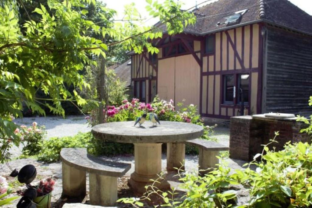 eine Vogelstatue auf einem Steintisch im Garten in der Unterkunft Gîtes Famille En Othe in Bouilly