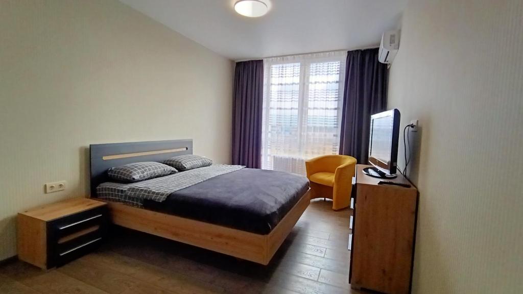 - une chambre avec un lit et une télévision à écran plat dans l'établissement 093 ЖК Щасливий нові апартаменти біля Кільцевоі, à Kiev