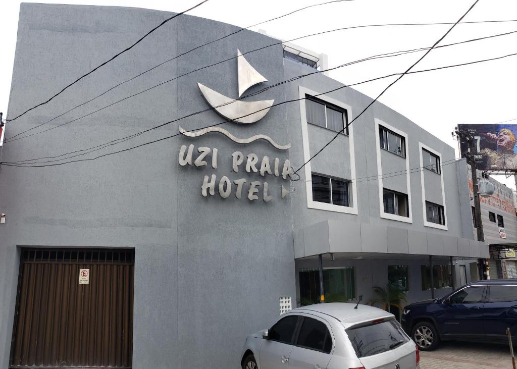 un coche blanco estacionado frente a un hotel en Hotel Uzi Praia, en Recife