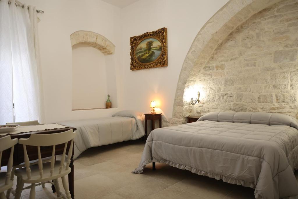 een hotelkamer met 2 bedden en een tafel en een stoel bij Antico Monastero in Bitonto