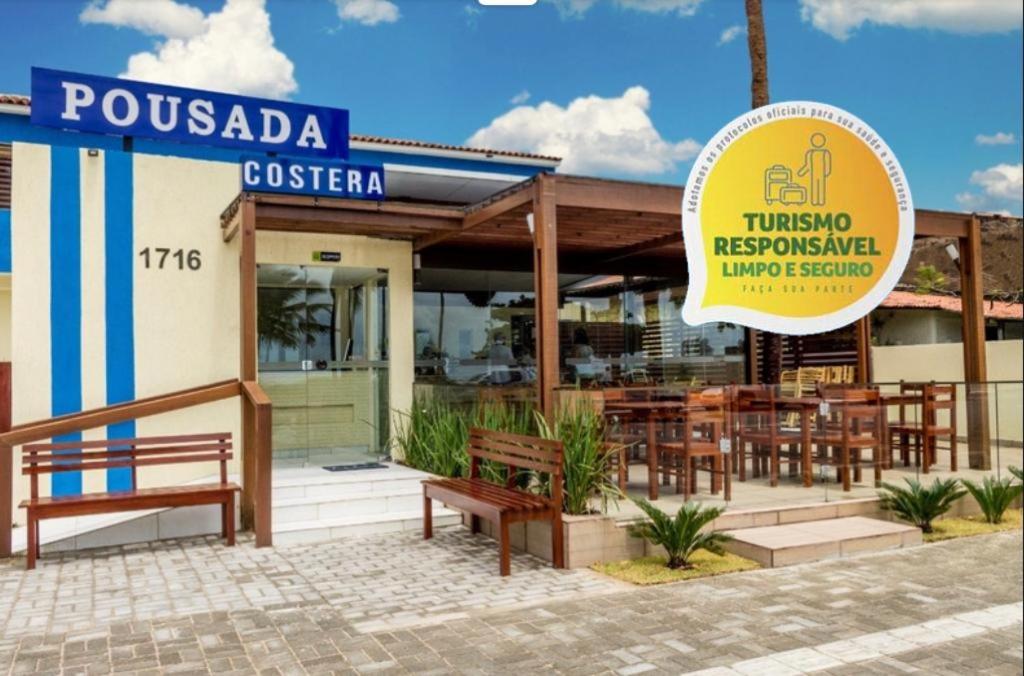 a restaurant with benches in front of a building at Pousada Costera in João Pessoa